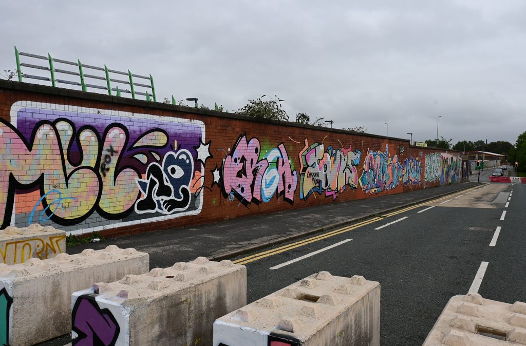 Graffiti along a roadside wall